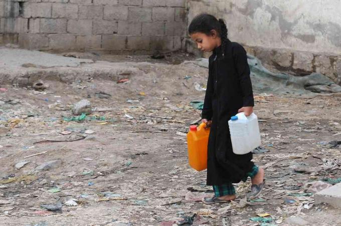 طفلة صغيرة تحمل أوعية مملوءة بالمياه النظيفة من مضخة خيرية خلال أزمة المياه النظيفة المستمرة في اليمن