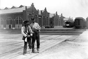 جنديان يقفان بجانب مبنى بولمان ويدربان السيارات بأذرع مغلقة وزجاجة من الخمور خلال 1894 شيكاغو بولمان سترايك