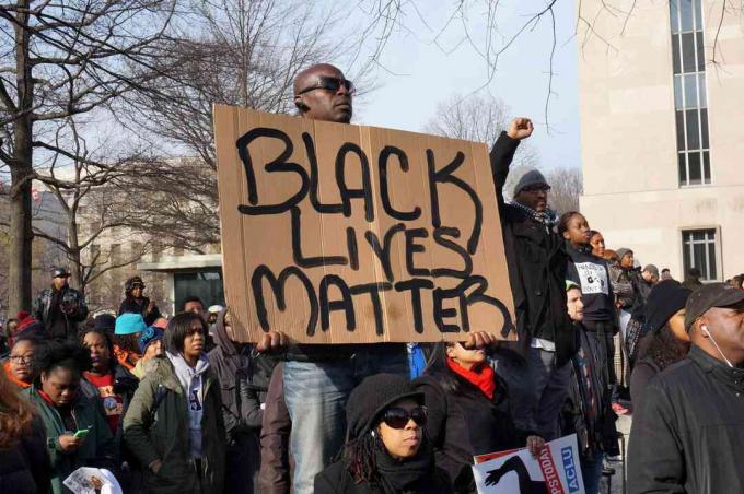 رجل يحتج على وفاة مايكل براون وإريك غارنر وتامر رايس يعرض مسألة حياة السود في واشنطن العاصمة.