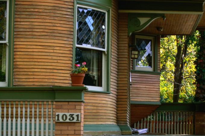 تفاصيل من شرفة منزل مدورة ، انحياز من الخشب الطبيعي مع تقليم أخضر ، نوافذ مزدوجة معلقة ، طرز زخرفية