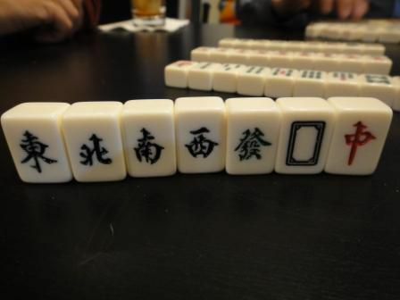 قرميدات الرياح والتنين في مجموعة Mahjong تقف منتصبة على طاولة.