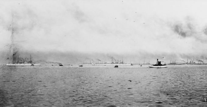 البوارج للأسطول الأبيض العظيم في الميناء مع الأسطول الياباني. حرفة صغيرة في المقدمة.