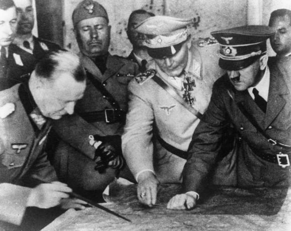 أدولف هتلر (1889 - 1945) ، وهيرمان جورينج (1893 - 1946) وآخرون يخططون لاستراتيجية عسكرية في مقر الجيش الألماني. في الخلفية ، الديكتاتور الإيطالي بينيتو موسوليني ، حوالي عام 1940.