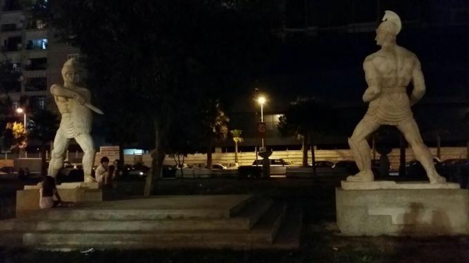 تماثيل لمصارعين تواجهان في ساحة عامة.
