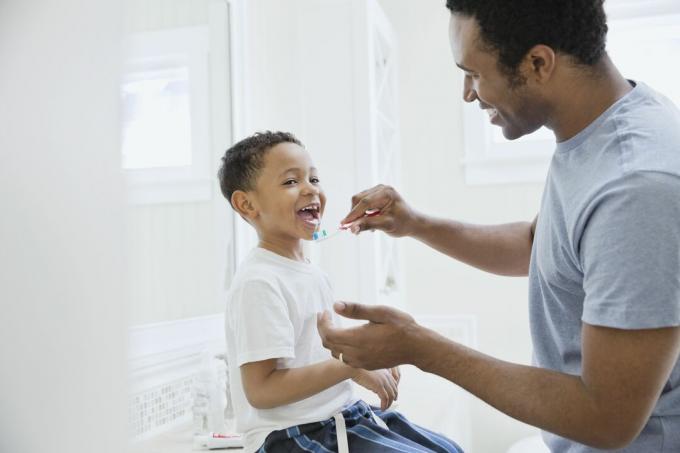 أب سعيد ينظف أسنان ابنه في الحمام