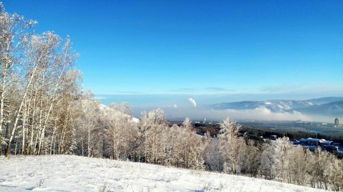 منظر خلاب لمناظر طبيعية مغطاة بالثلوج مقابل سماء زرقاء