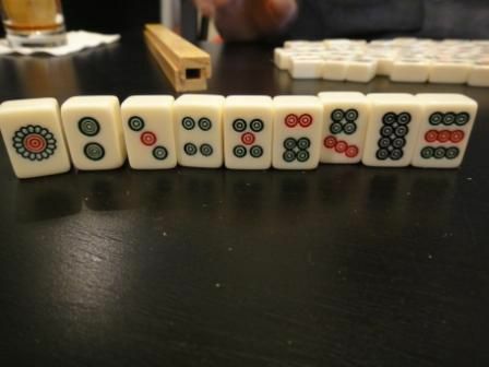 البدلة الحجرية لمجموعة قياسية من بلاط Mahjong واقفة على طاولة.