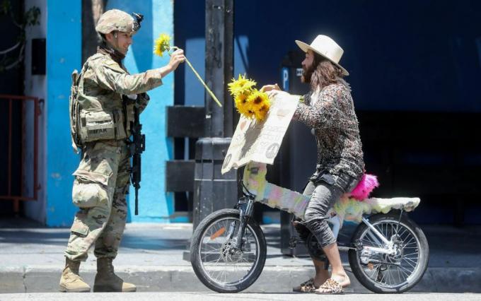 جندي من الحرس الوطني يتلقى وردة من أحد المتظاهرين خلال مظاهرة سلمية احتجاجا على وفاة جورج فلويد في هوليوود ، 3 يونيو ، 2020.