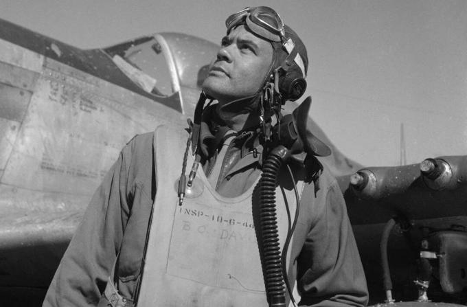 بنيامين أو. ديفيس يرتدي بدلة طيران وخوذة يقف أمام مقاتلة موستانج P-51.