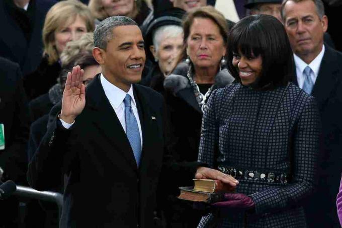 باراك أوباما ويده على الأناجيل يؤدي اليمين أمام زوجته لولايته الثانية.