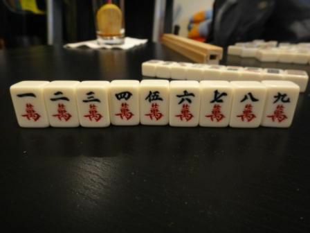 بدلة شخصية لمجموعة من بلاط Mahjong تجلس على طاولة.