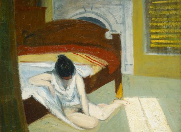 امرأة شابة تجلس نصف عارية على الأرض بجانب سرير في غرفة مظلمة.