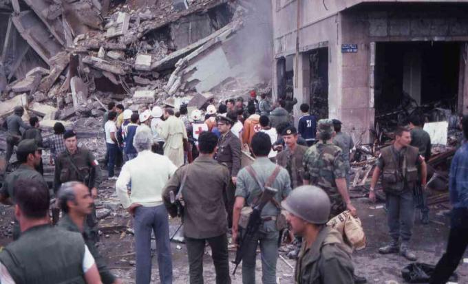 حشد من الجنود ومقدمي المساعدات يقفون وسط الدمار والأضرار في موقع التفجير الانتحاري للسفارة الأمريكية ، بيروت ، لبنان ، 18 أبريل 1983.