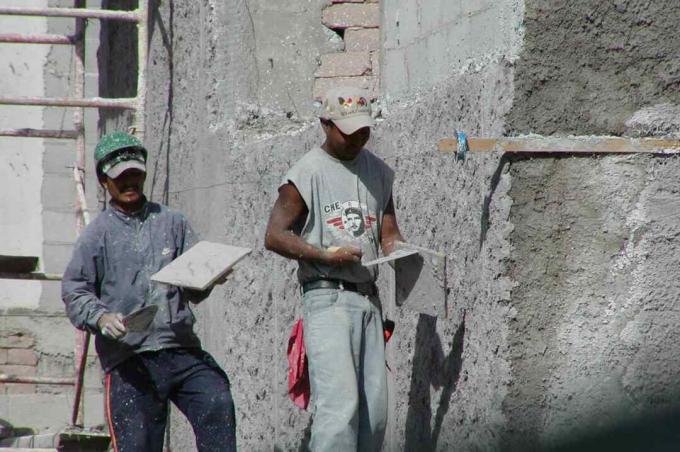 عاملان يضعان طبقة من الجص مع المسجات